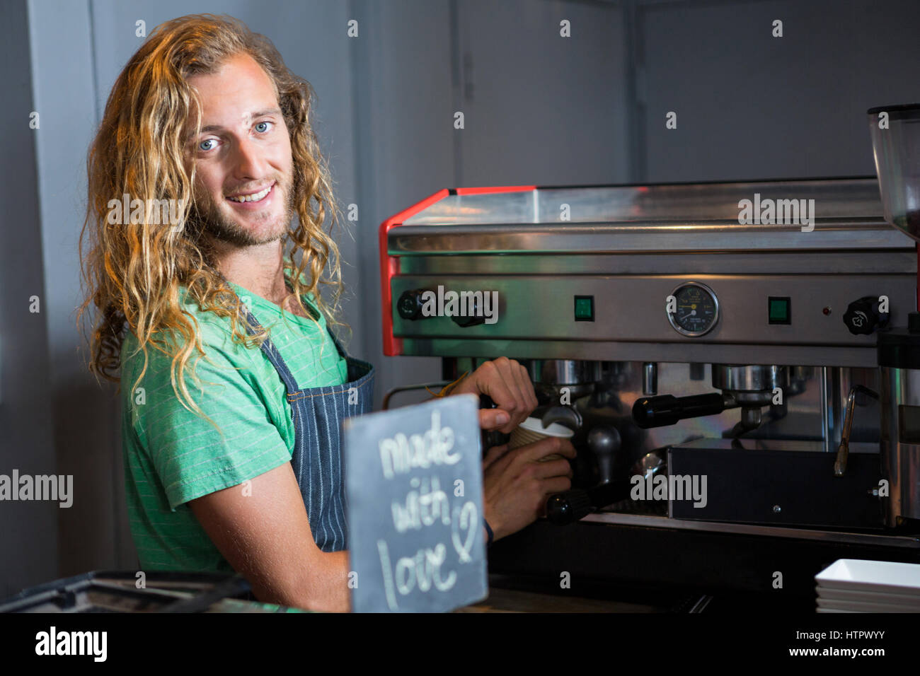 Portrait of barista preparing coffee in coffee machine at coffee shop Stock Photo