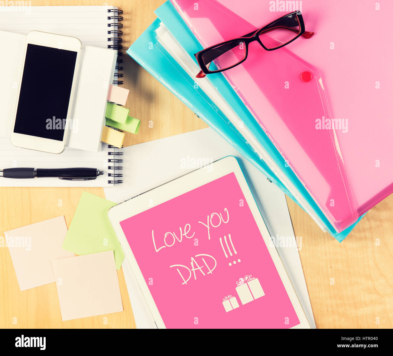 Messy office table with Fathers day card on digital tablet. View from
