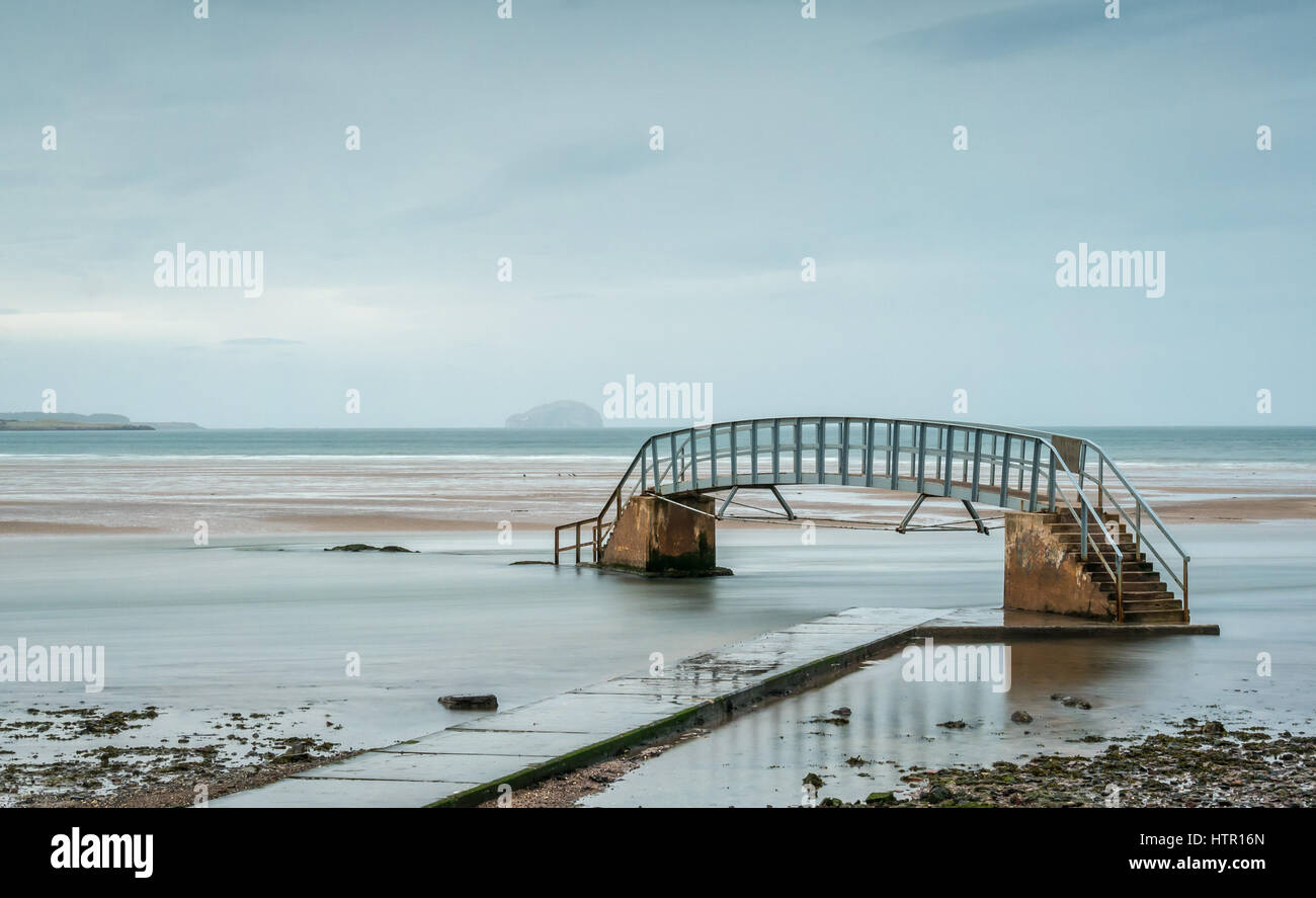 Footbridge only passable at low tide called Bridge to Nowhere, surrounded by high tide water, Belhaven Bay, Dunbar, East Lothian, Scotland, UK Stock Photo