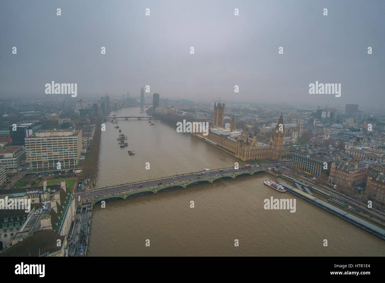 Panoramic Aerial view of Thames river in London against a cloudy sky in a foggy weather. London, United Kingdom. Stock Photo