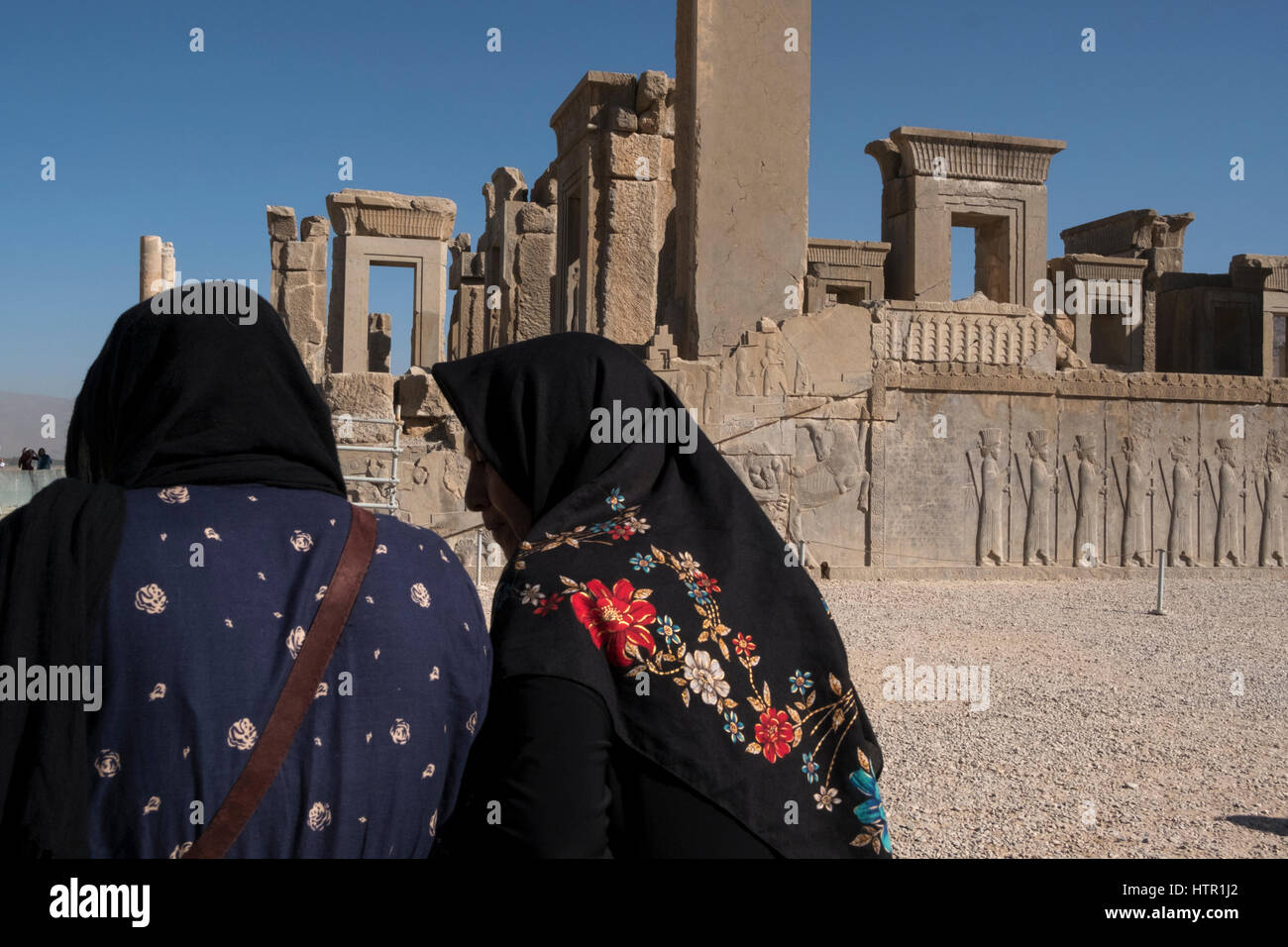 Middle aged women rest in front of ruins at the ancient city of Persepolis, Fans, Province, Iran. Stock Photo