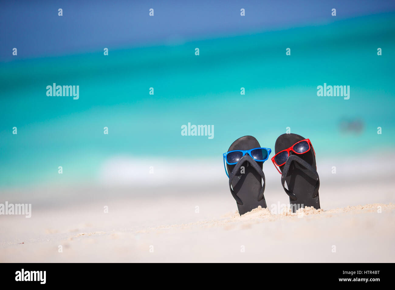 Summer black flip flops with sunglasses on white beach Stock Photo - Alamy