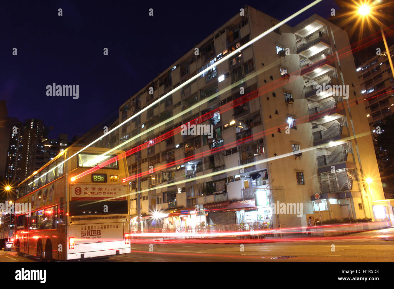 Exterior of an old public housing in ngau tau kok, Hong Kong, with light trail of a passing by bus Stock Photo