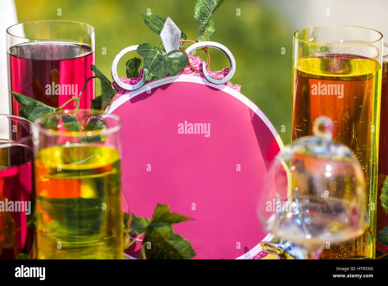 Purple oval frame between glasses with colored liquid, closeup Stock