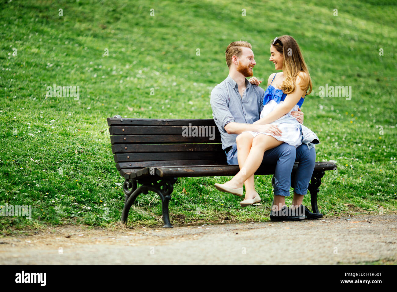 Romantic couple in park sitting on bench Stock Photo - Alamy