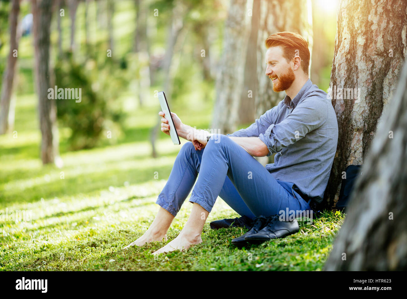 Handsome student reading and studying in park Stock Photo