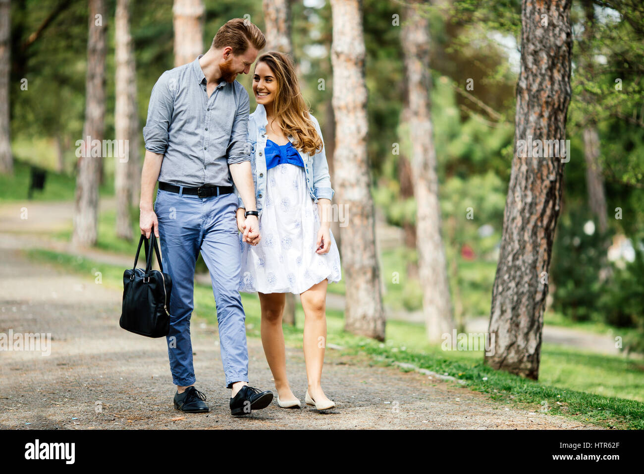 Beautiful couple taking a walk in city park Stock Photo - Alamy