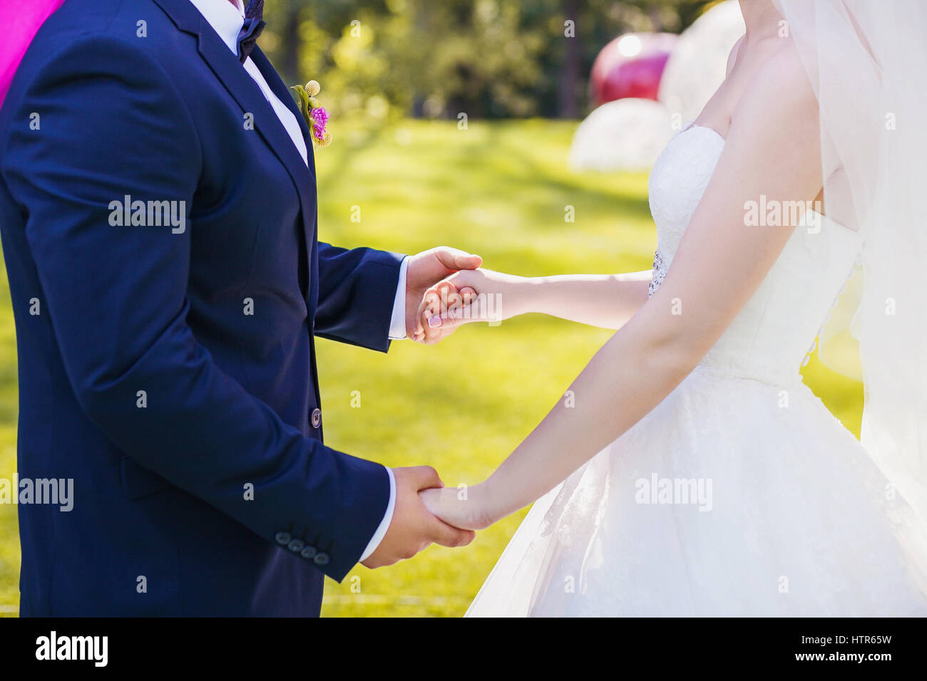 Newlyweds staying arm in arm, with wedding rings, closeup Stock Photo