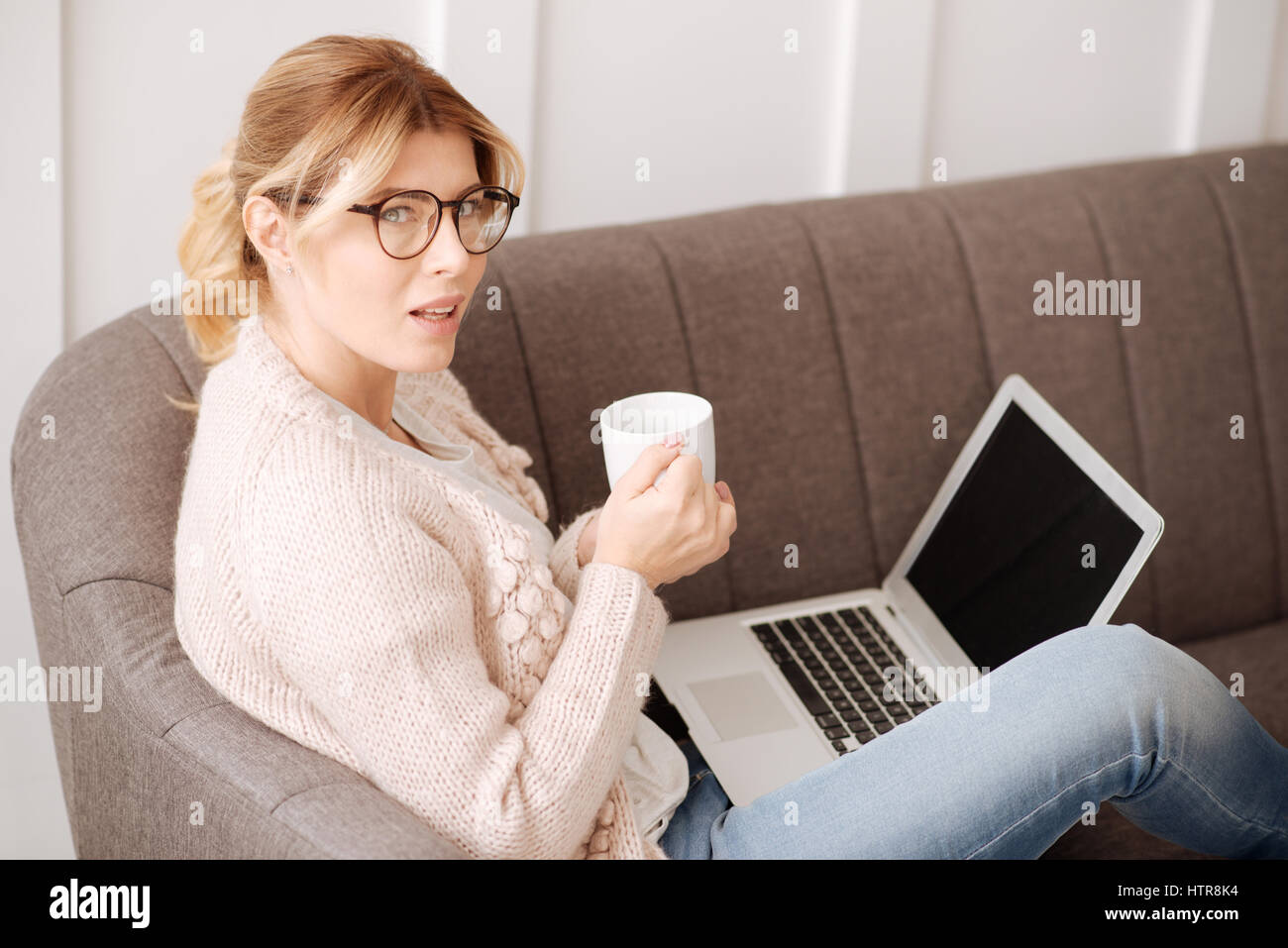 Taking a break. Hard working thoughtful nice woman sitting on the sofa