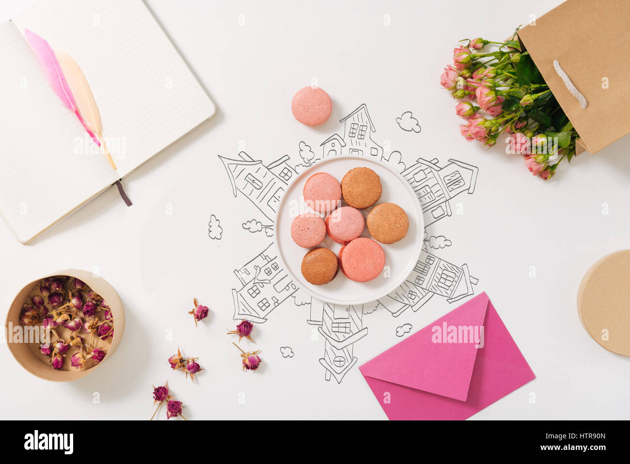 Sweet traveling. Top view of plate with macarones standing on the table near pack with flowers Stock Photo