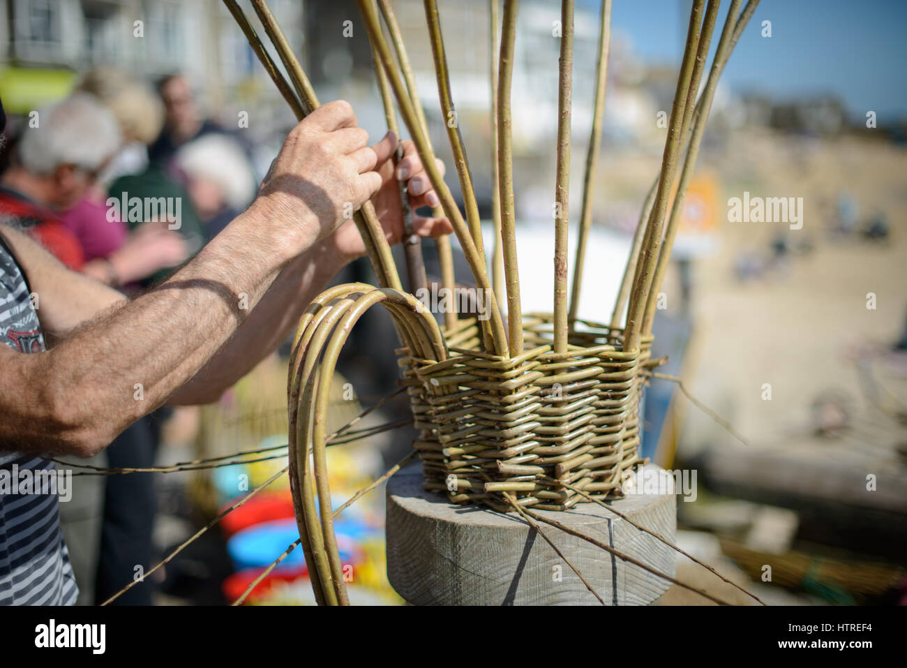 A man makes traditional cornish willow lobster pots called Withy Pots on the quayside of the harbour at St Ives, Cornwall, England, UK. Stock Photo