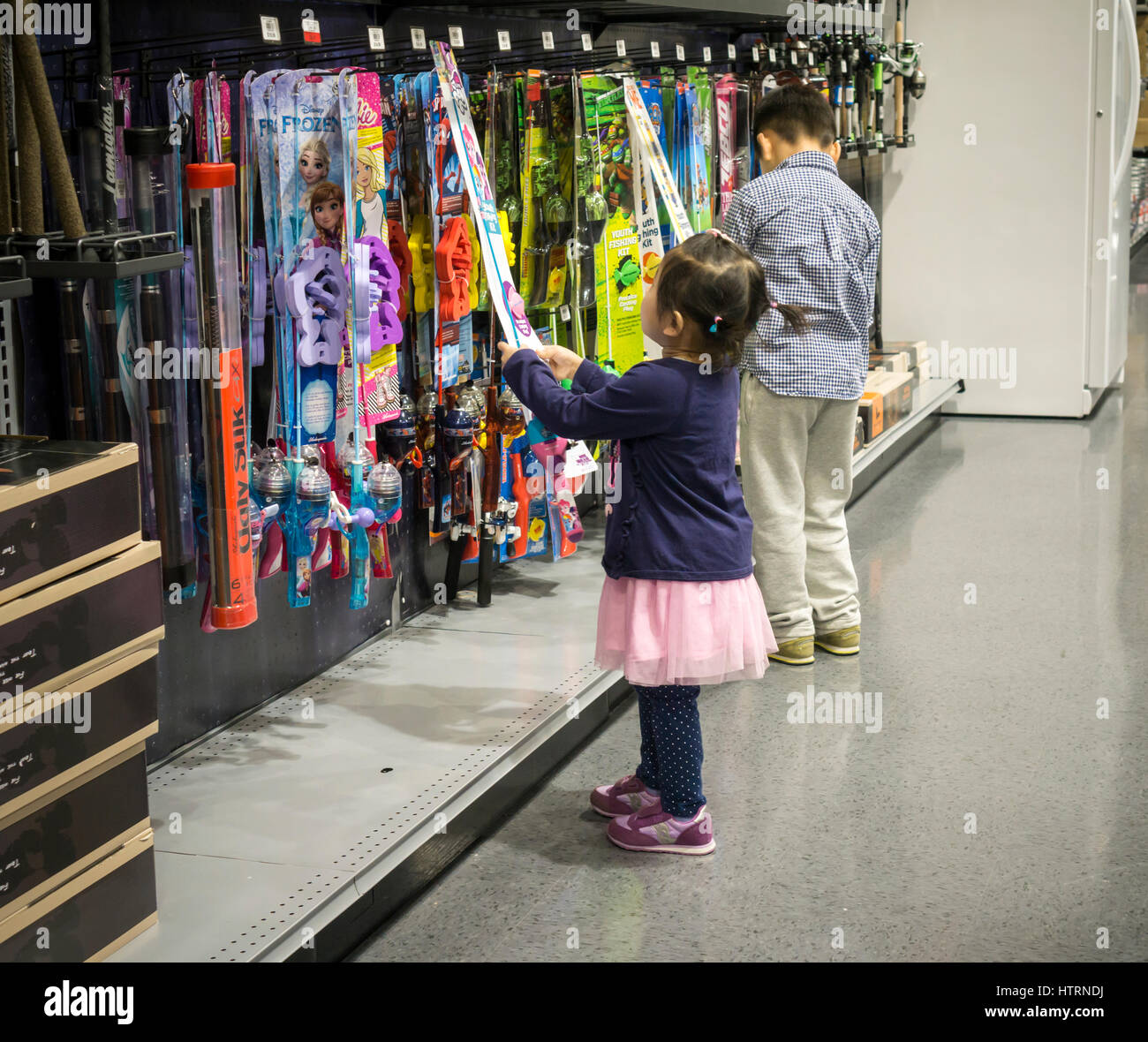 Children inspect fishing equipment in the new Dick's Sporting Goods store  in the Glendale neighborhood of Queens in New York during its grand opening  sales on Saturday, March 11, 2017. The new