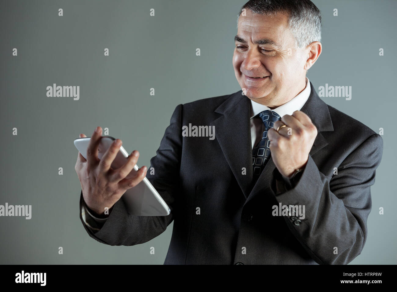Jubilant businessman cheering a success punching the air with his fist ...