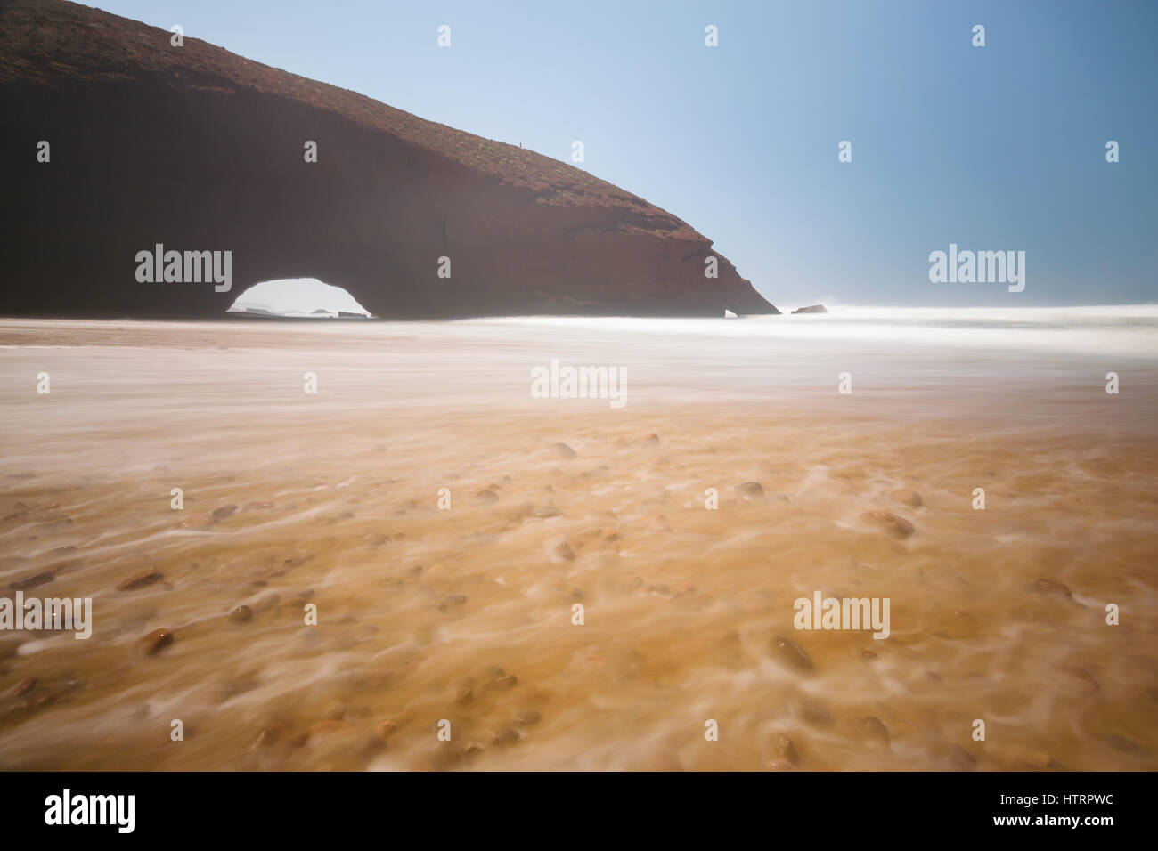 Long exposure of the Red arches and rocky beach at the Atlantic Ocean in the region Sous-Massa-Draa, Sidi Ifni, Legzira, Morocco, Africa. Stock Photo