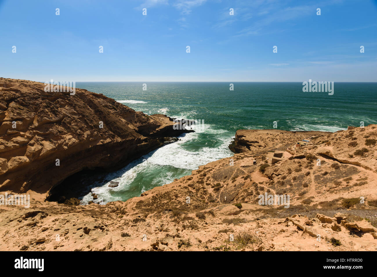 Colorful coastline with a view over a small bay with a few fishing lodges in the Souss-Massa National Park at the Atlantic Ocean in Morooco, Africa. Stock Photo