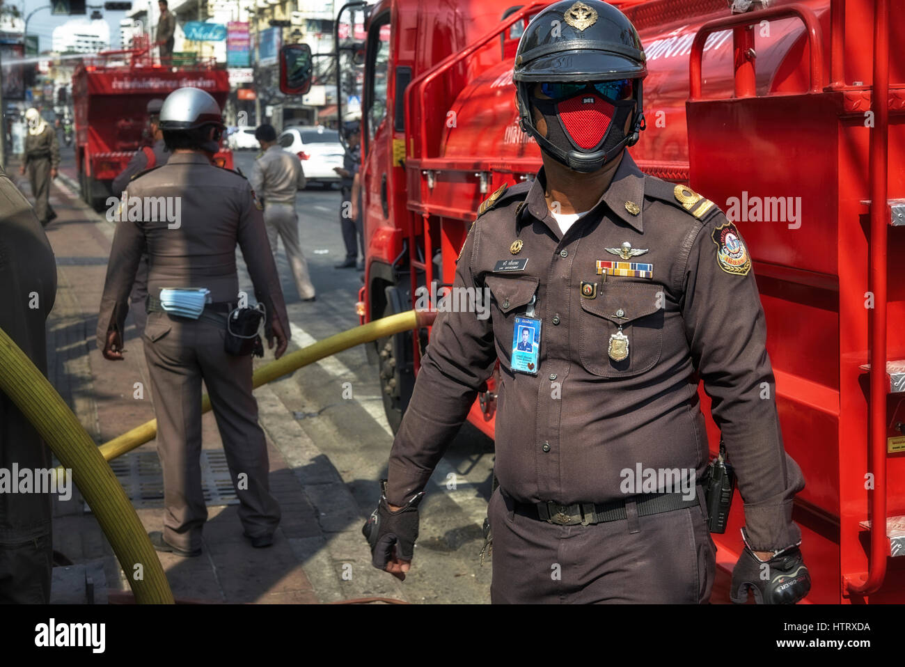 Thailand Police Officer wearing a pollution face mask attending a fire incident. Police Thailand, Southeast Asia Stock Photo