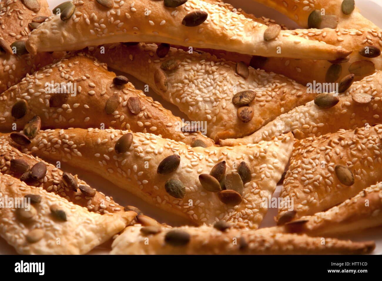 flaky Triangles  puff pastry Sprinkle Seeds pumpkin, sesame seeds, background Stock Photo