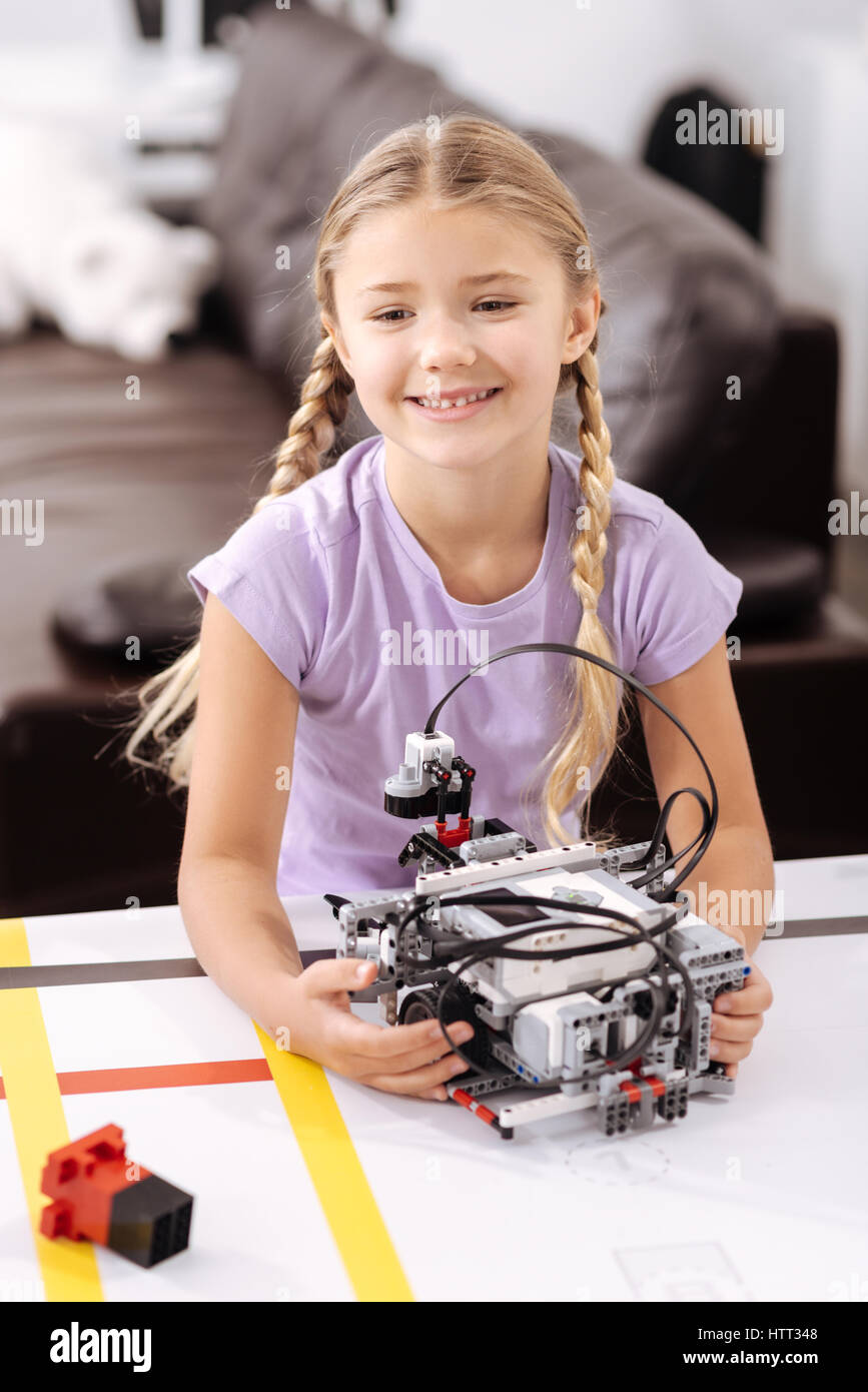 Happy pupil holding electronic robot at school Stock Photo