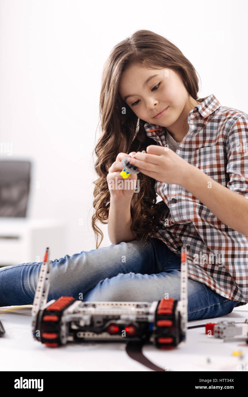Delighted girl repairing electronic toy at the robotics laboratory