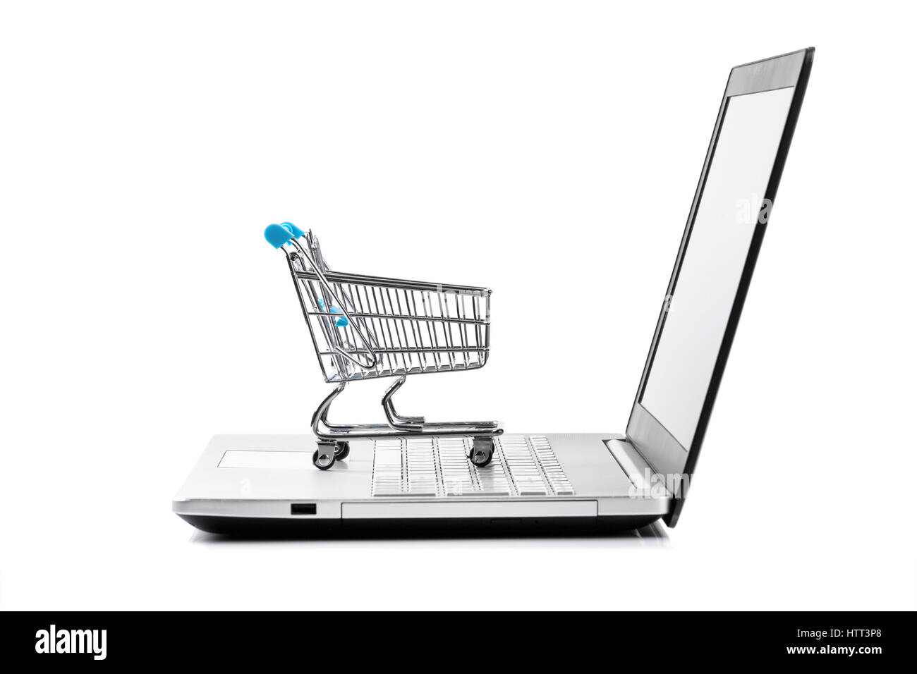 internet store concept - shopping cart on laptop keyboard Stock Photo