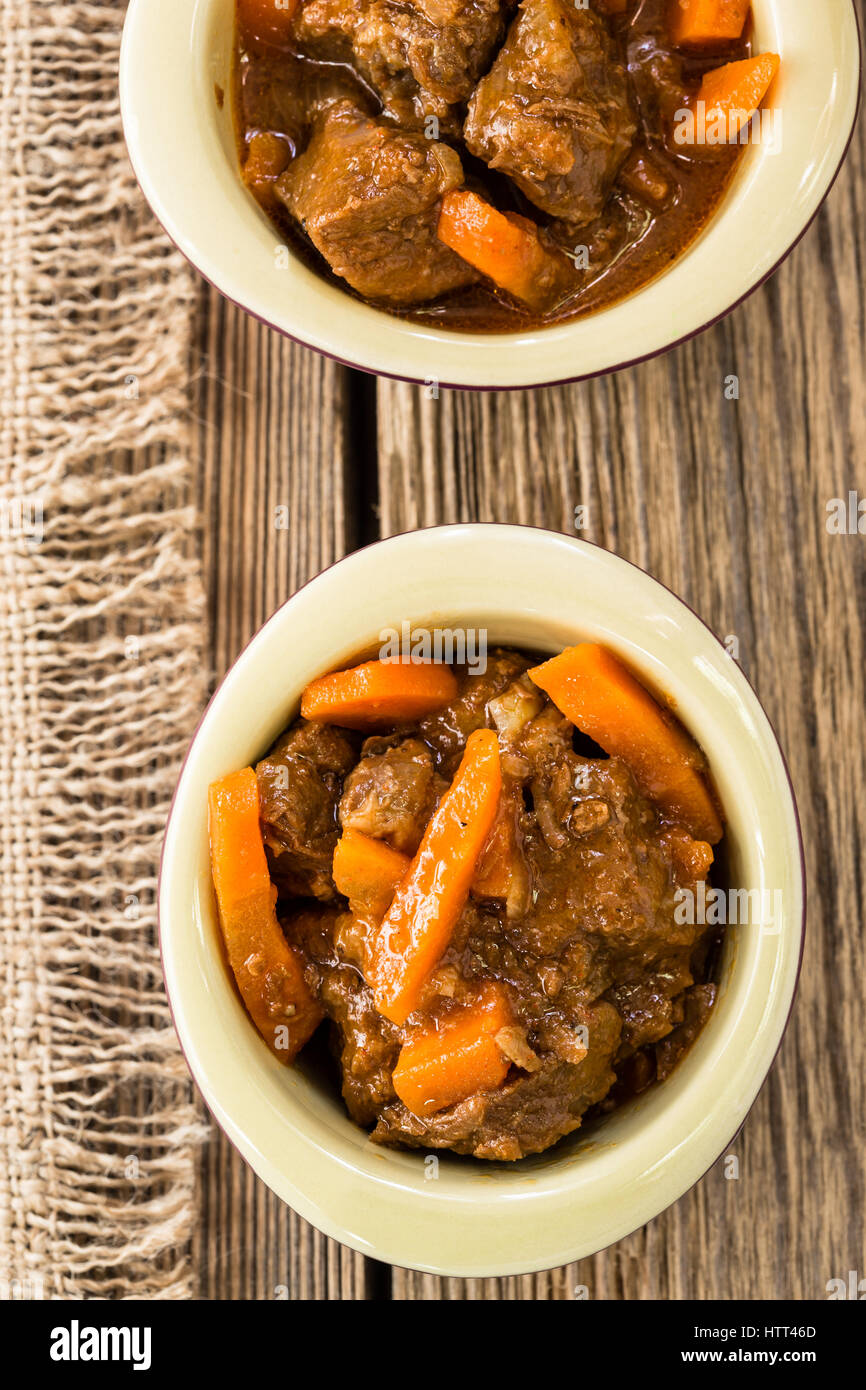 Beef stew with carrot. Traditional french beef goulash in ceramic pots viewed from above Stock Photo