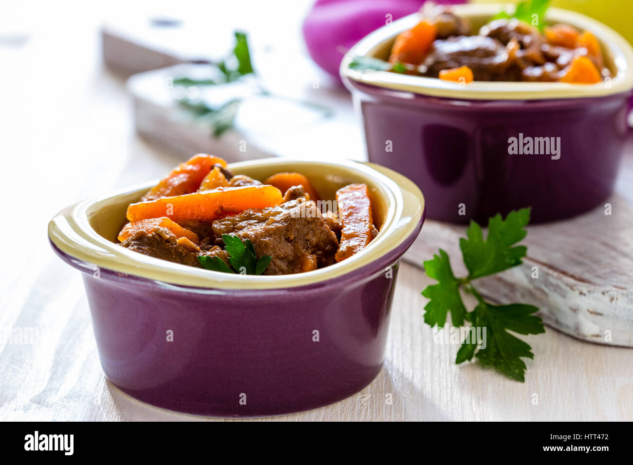 Beef stew with carrot. Traditional french beef goulash in lilac ceramic pots Stock Photo