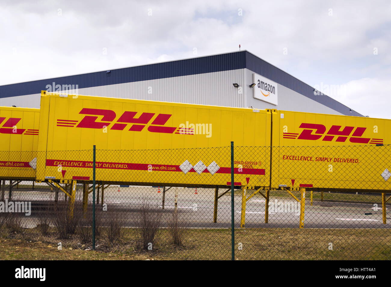 DOBROVIZ, CZECH REPUBLIC - MARCH 12: DHL shipping containers in front of Amazon logistics building on March 12, 2017 in Dobroviz, Czech republic. Stock Photo