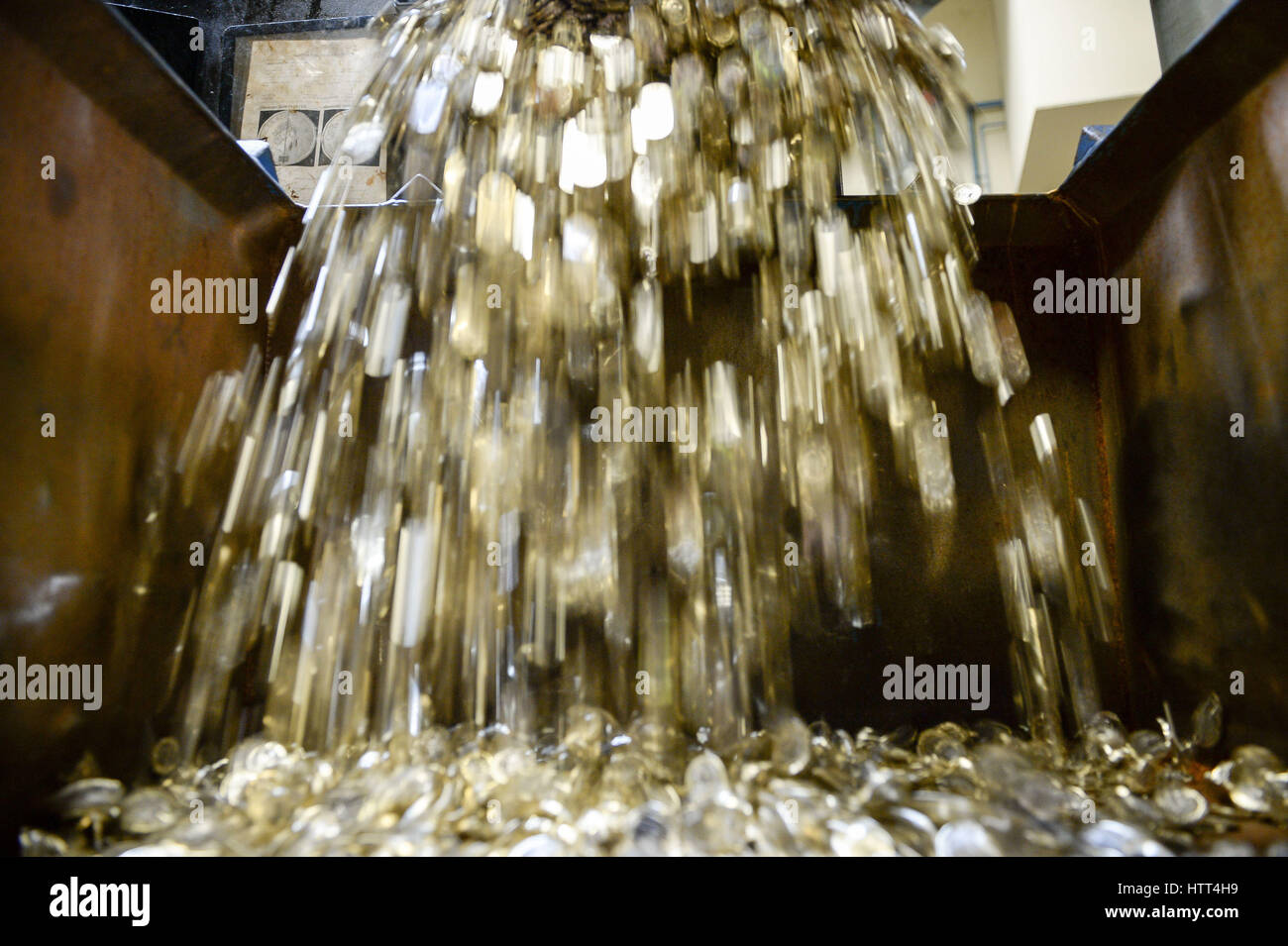 Editorial Use only &ETH; NO COMMERCIAL USE New 12-sided one pound coins fall from a 'tote' into a metal crate as they are minted at the Royal Mint in Llantrisant, Wales. Stock Photo