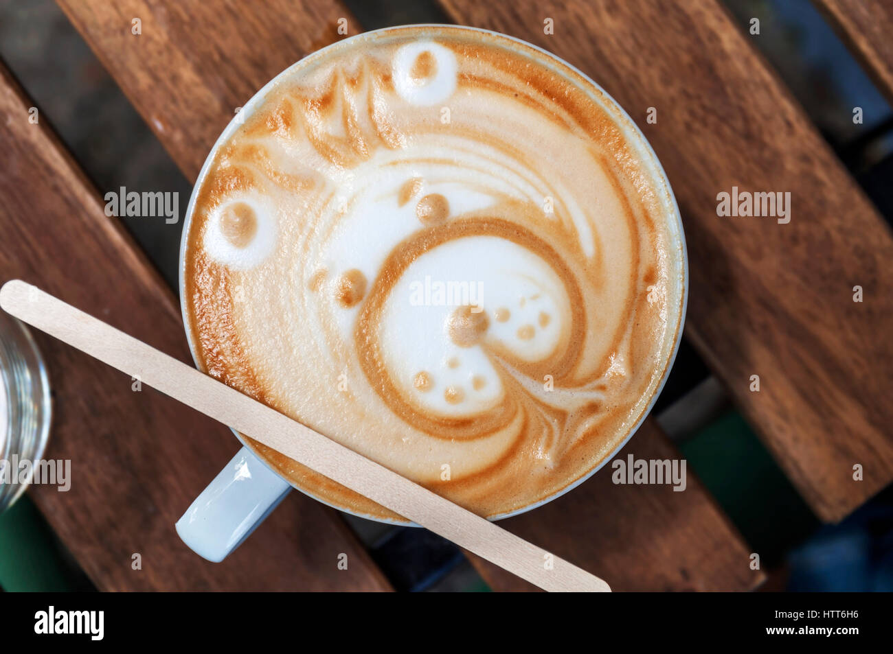 Latte art bear on wooden table Stock Photo