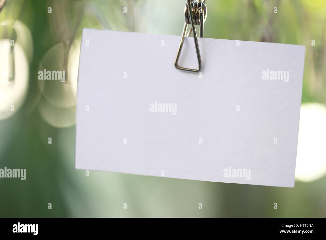 white paper notes hanging in a clothesline on green bokeh background ...