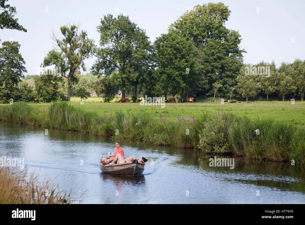 Nice girls sailing a rent boat on Netherlands river in the summertime Stock Photo