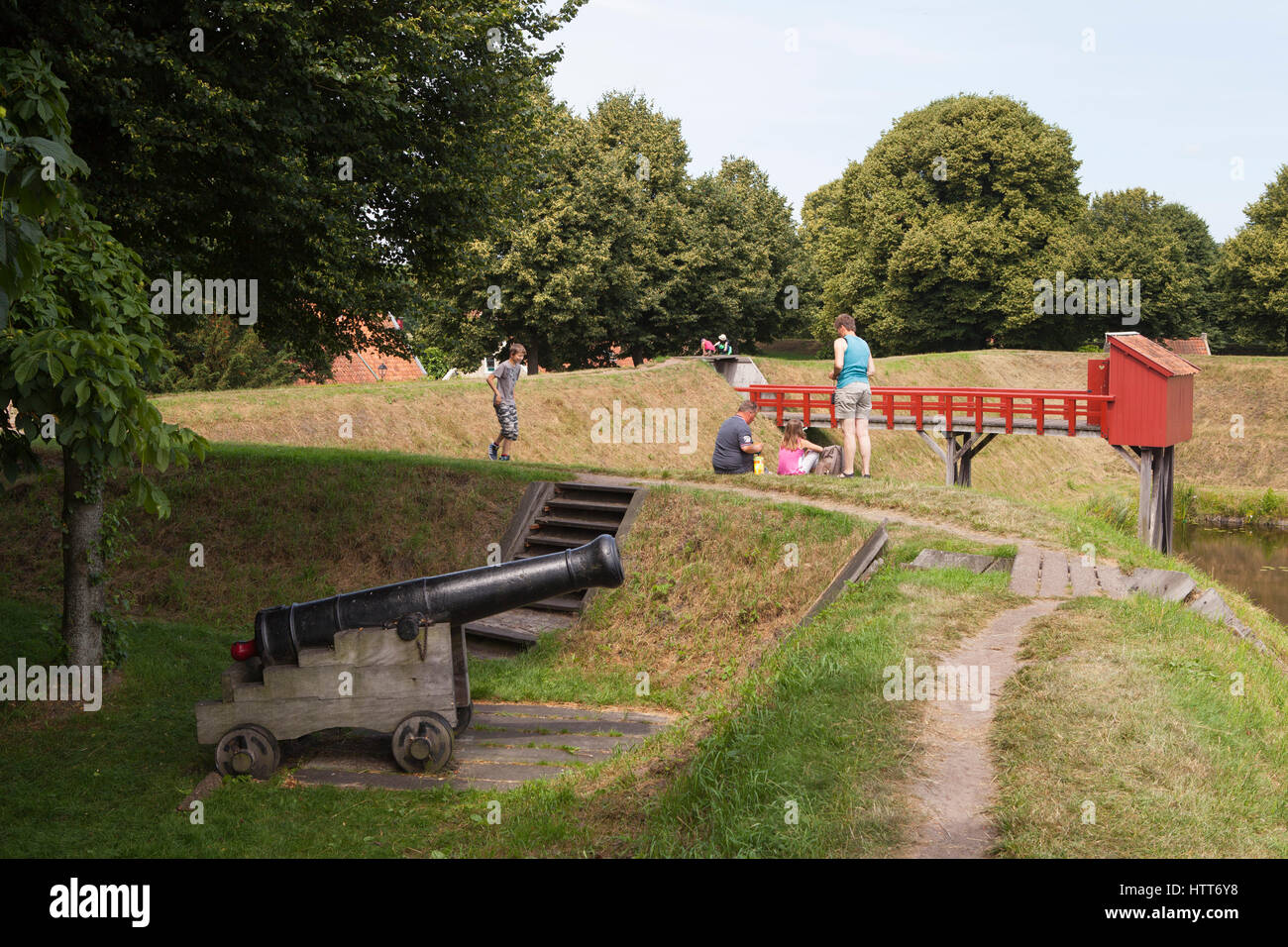 Tourists at the city wall with a cannon at historical fortress village Bourtange in the Netherlands Stock Photo