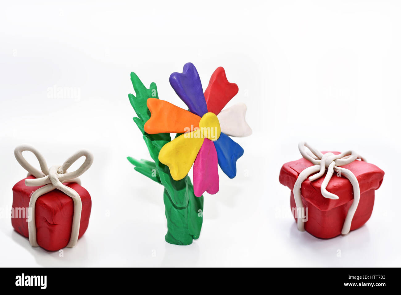 Red present with flower made from plasticine. Isolated on white background. Stock Photo