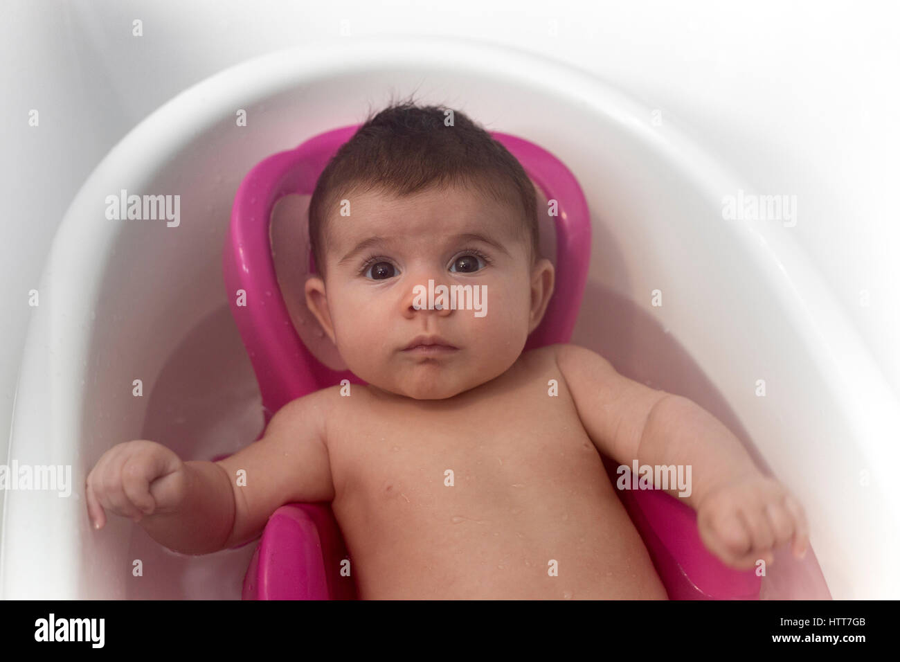 A surprised newborn in her bath. Nice relaxing time. Stock Photo