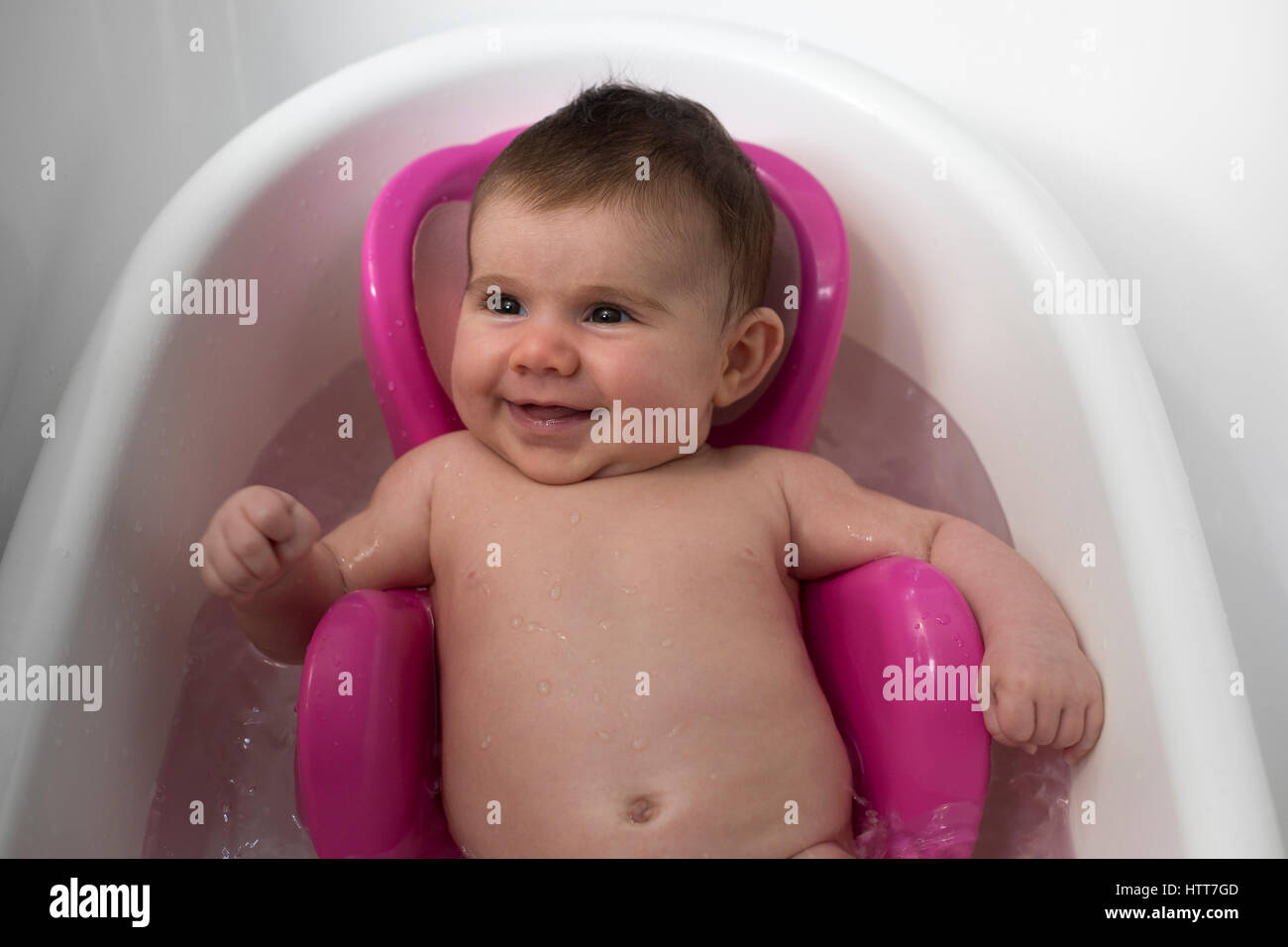 Portrait of a newborn smiling in her bath. Nice relaxing time. Stock Photo