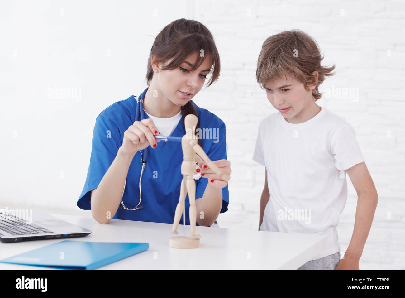 Doctor explain medicine to child using wooden doll Stock Photo