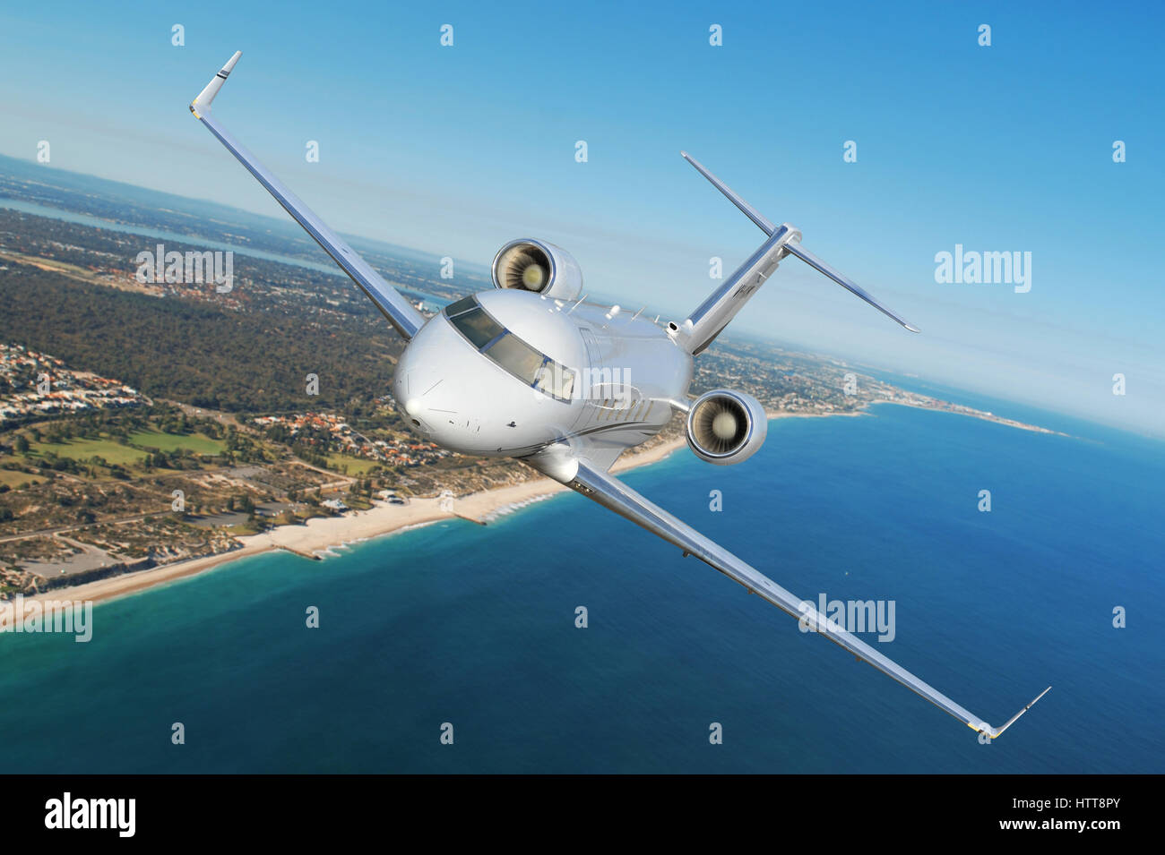 Air-to-air shot of a Bombardier Challenger CL604, twin engine business jet, flying above beach. Stock Photo