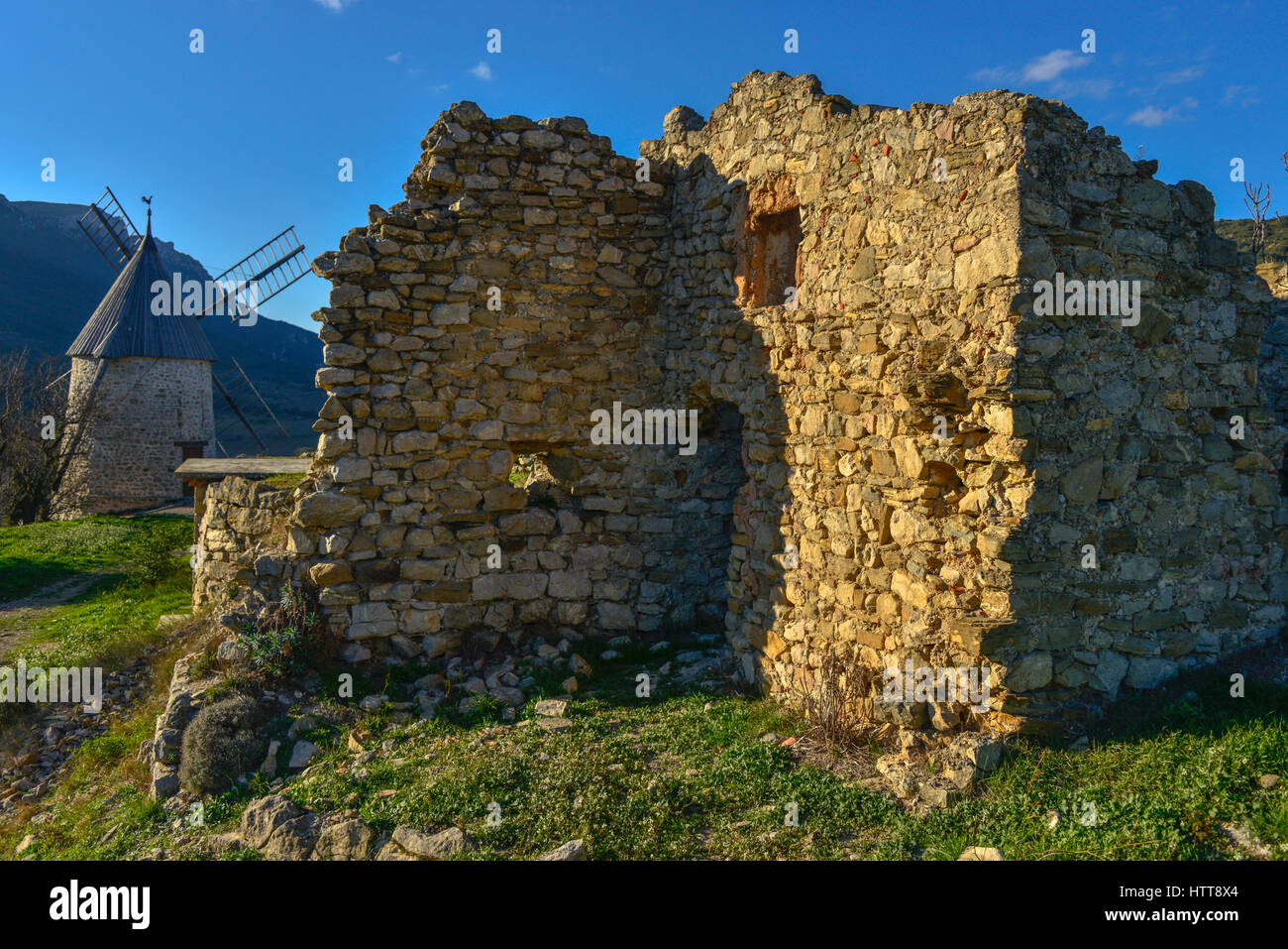 Ruined stone building and windmill at Cucugnan, in the Occitanie region of Southern France. Stock Photo