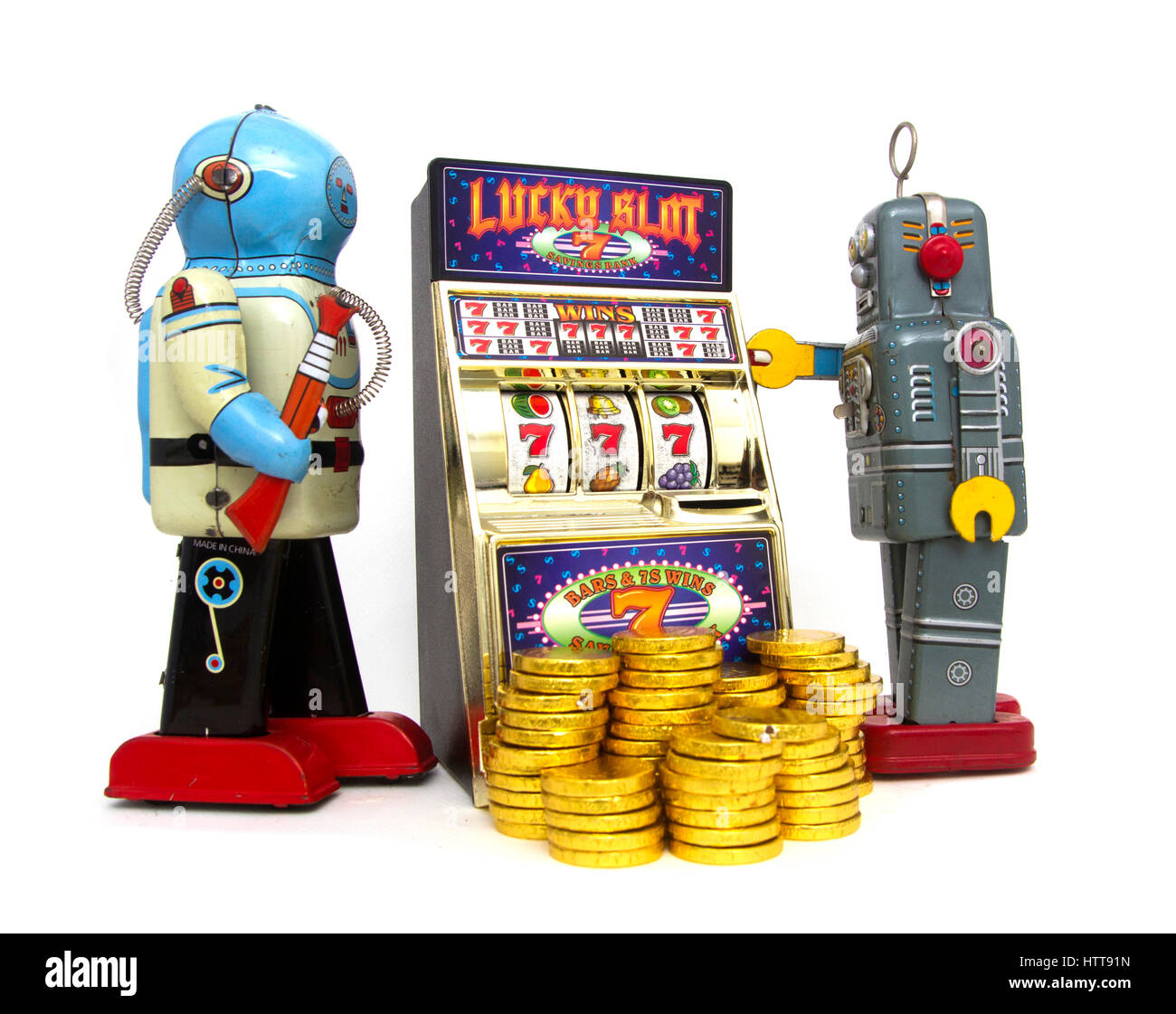 vintage robots gather around a old slot machine Stock Photo