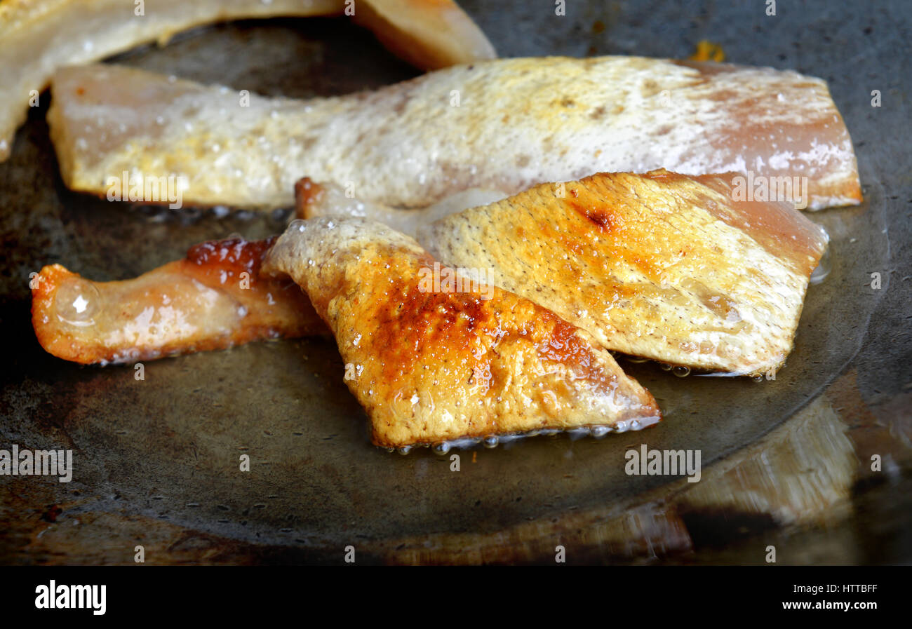 hot Fried pork skin in iron plate daylight Stock Photo
