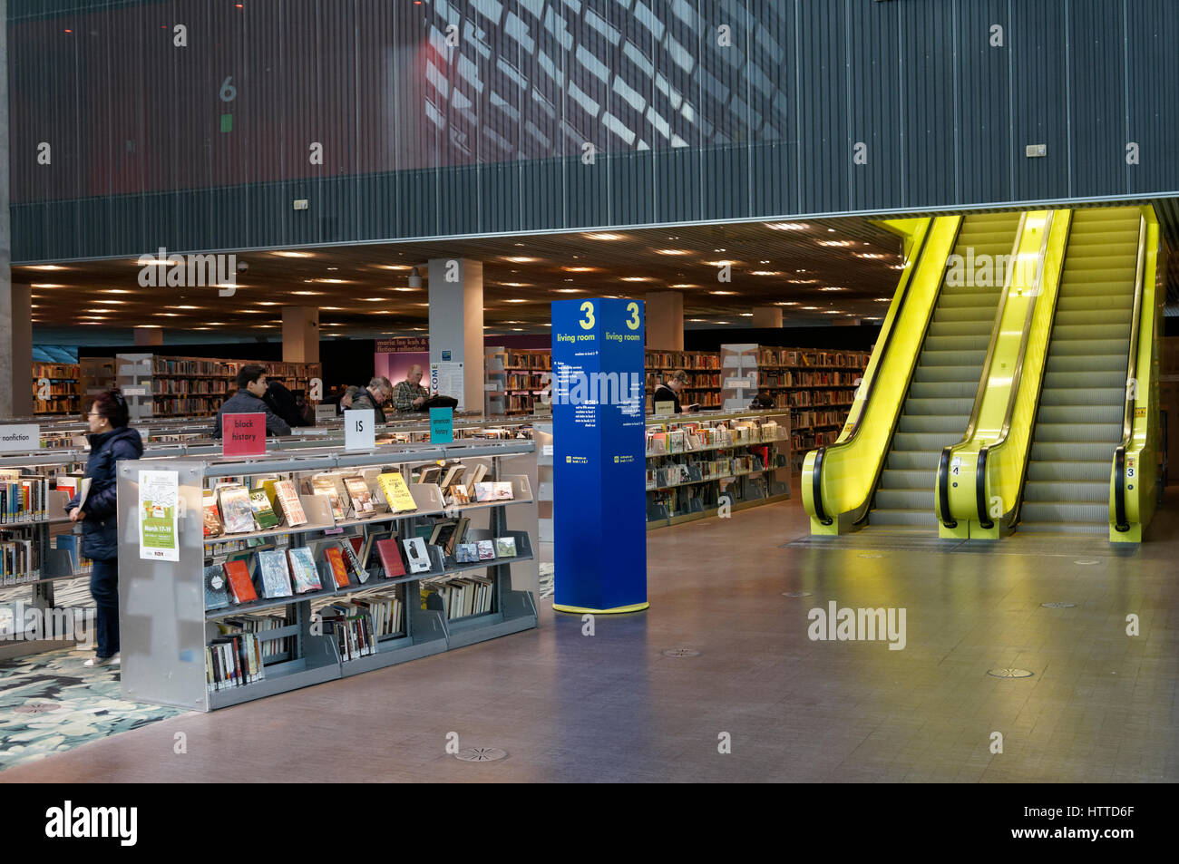 Book shelves and escalators in the Living Room on Level 3  of Seattle Central Library building in downtown Seattle, Washington state, USA Stock Photo
