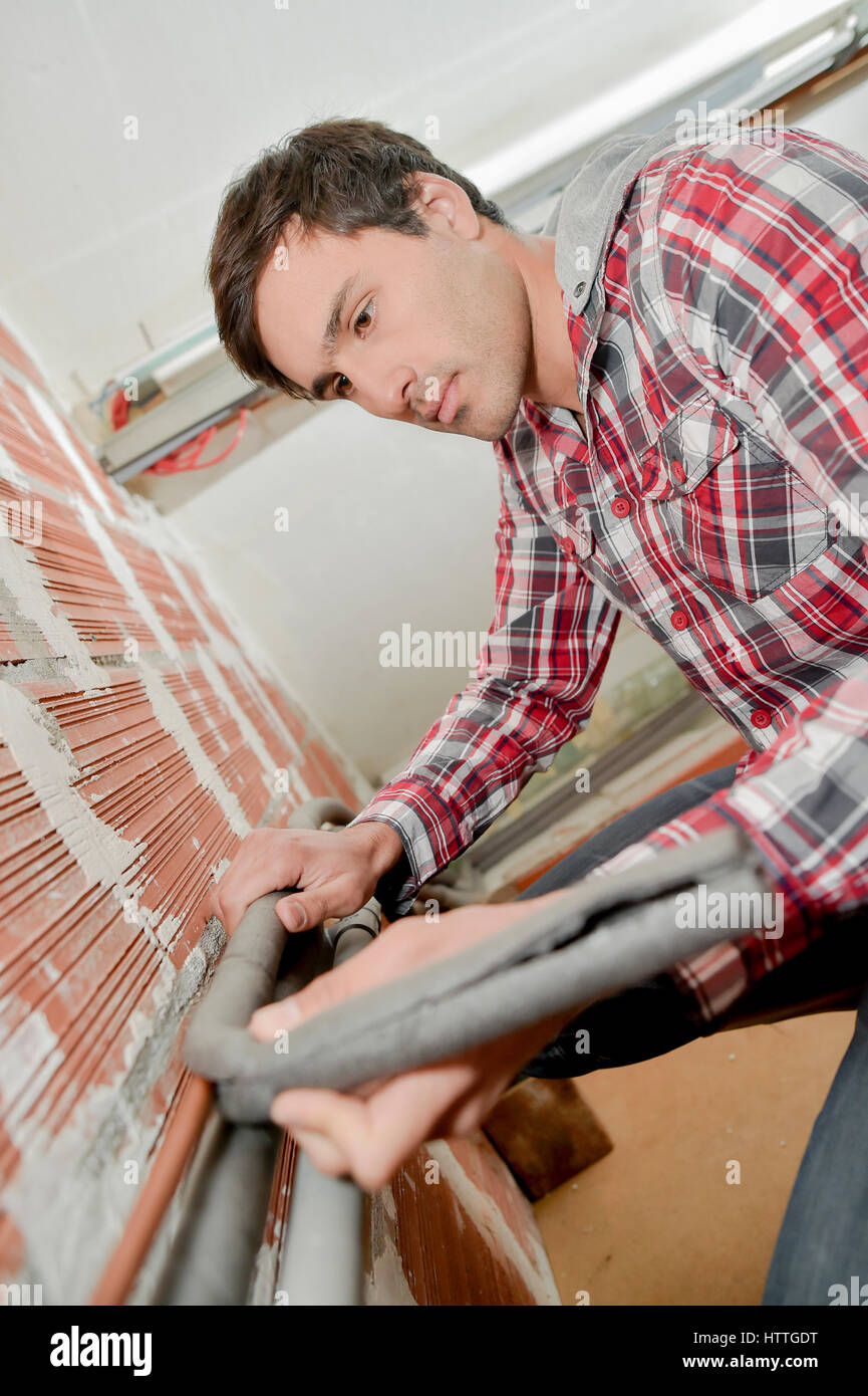 Man fitting insulation to pipes Stock Photo Alamy