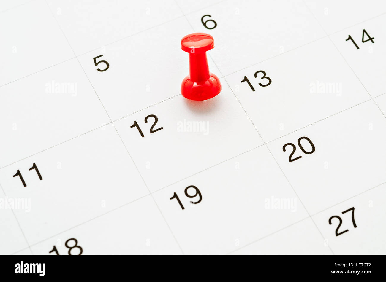 Red Thumb Tack on Calendar Page Stock Photo