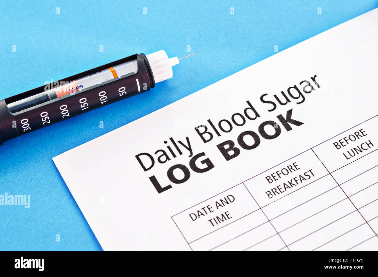 Insulin injection pen with daily blood Log Book on blue background Stock Photo Alamy