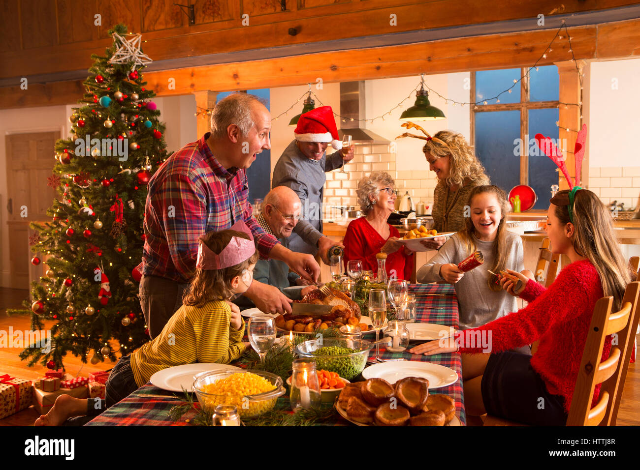 A large family are all helping serve Christmas dinner. Stock Photo