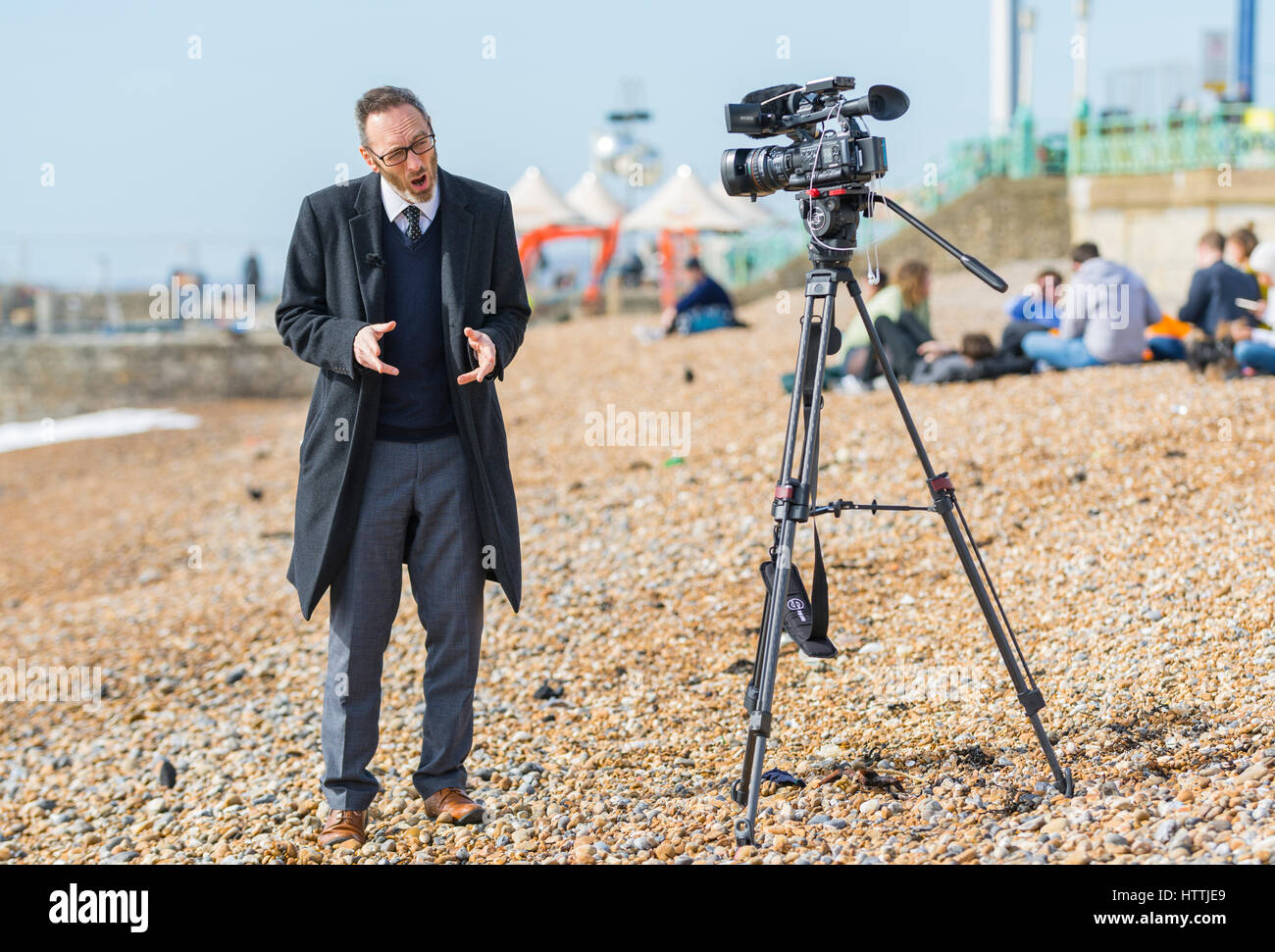 News reporter on a beach making an outside broadcast for a television.news programme. Stock Photo