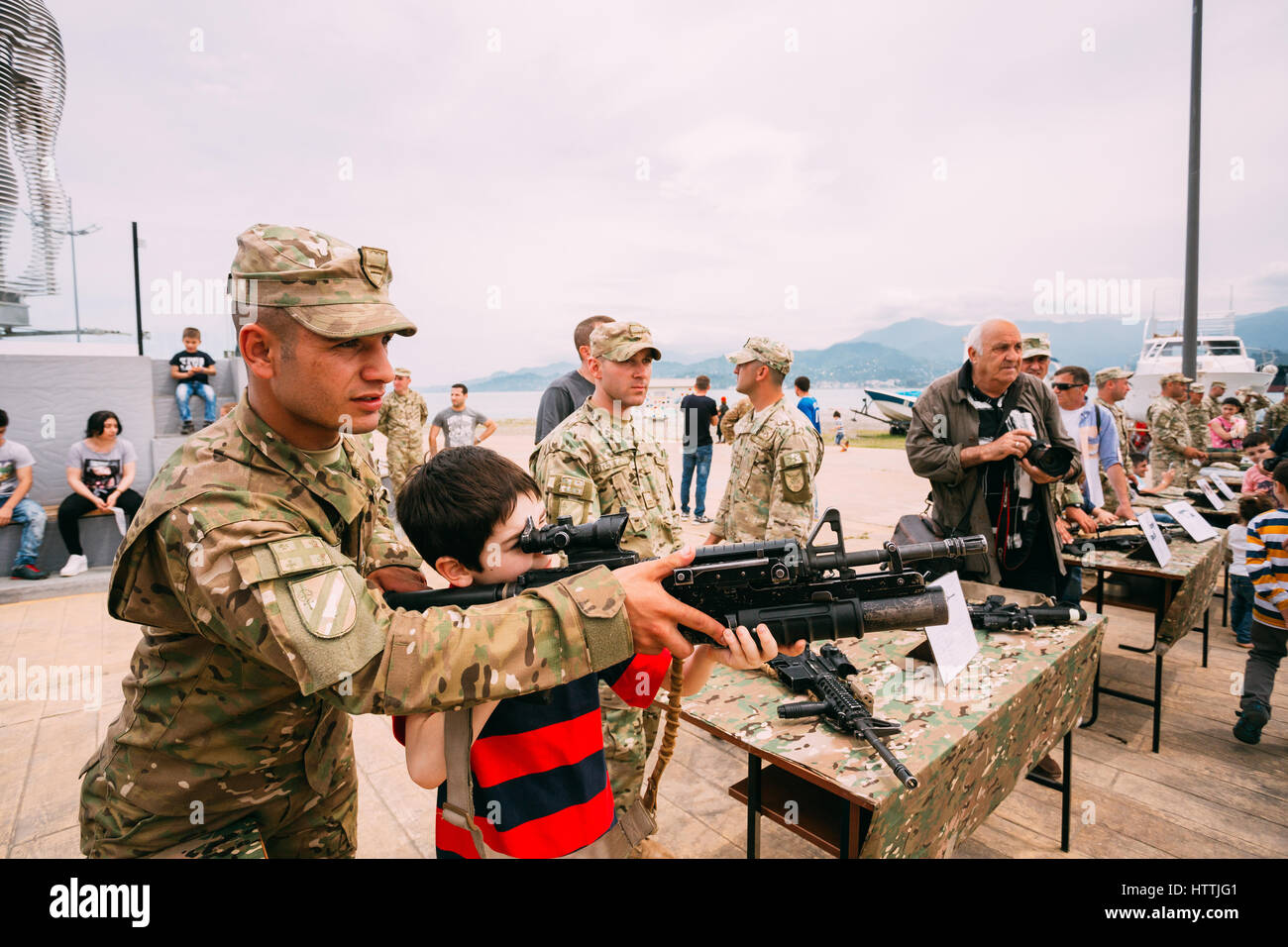 Batumi, Adjara, Georgia - May 26, 2016: Boy aiming M4 assault rifle at an exhibition of weapons during celebration of the national holiday - the Indep Stock Photo