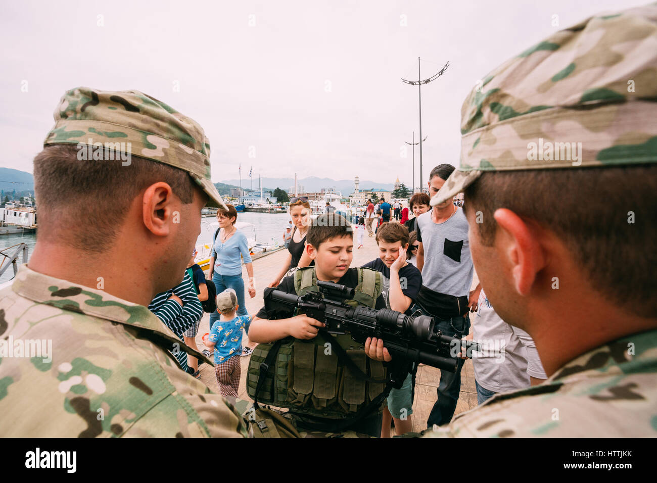 Batumi, Adjara, Georgia - May 26, 2016: Boy holding M4 assault rifle at an exhibition of weapons during celebration of the national holiday - the Inde Stock Photo