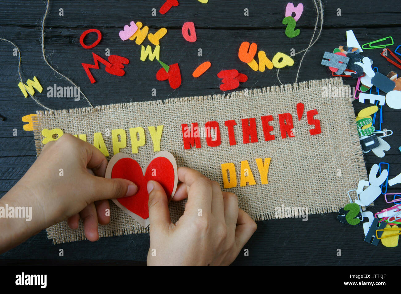 Happy mothers day with i love mom message,  idea from colorful letter on wooden background, woman hand cutting character to make gift for mother on ha Stock Photo