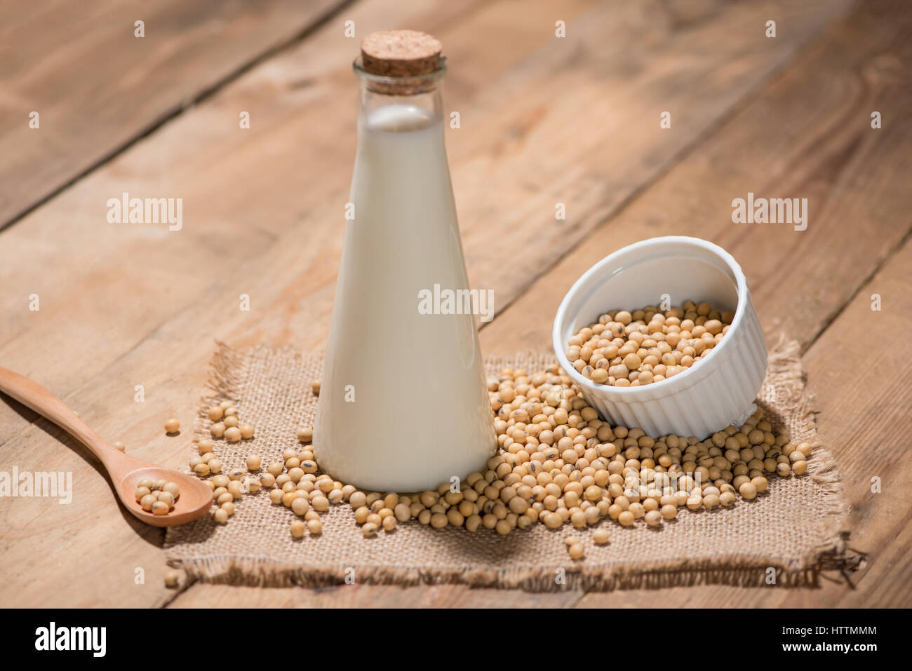 A bottle of soy milk or soya milk and soy beans on wooden table. Stock Photo
